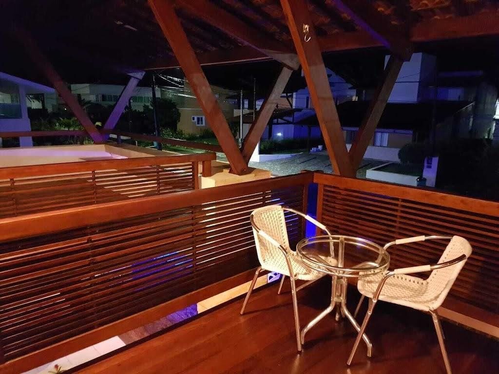 Deck de madeira iluminado à noite com mesa e cadeiras