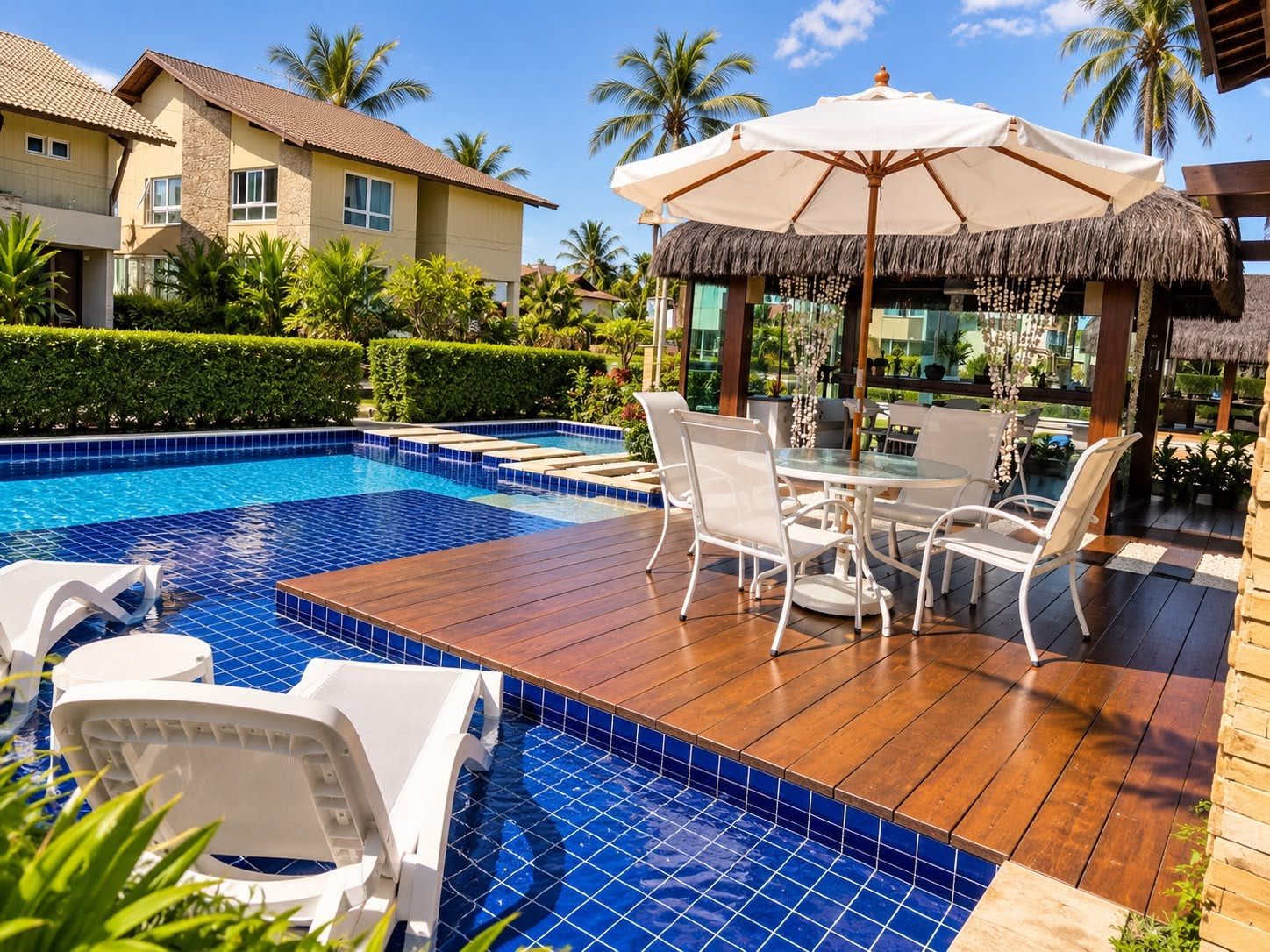Deck de madeira sobre a piscina, com mesa e guarda-sol