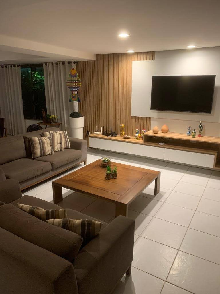 Sala de estar com sofá e painel de madeira