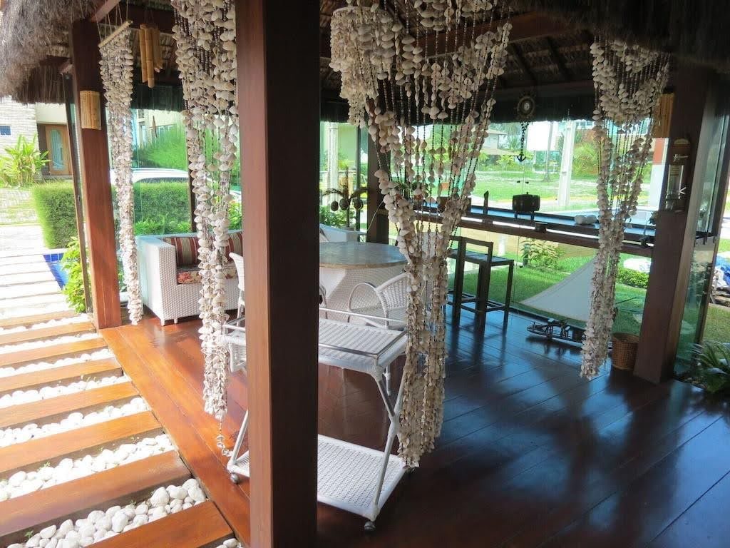Varanda com cortinas de conchas e mesa